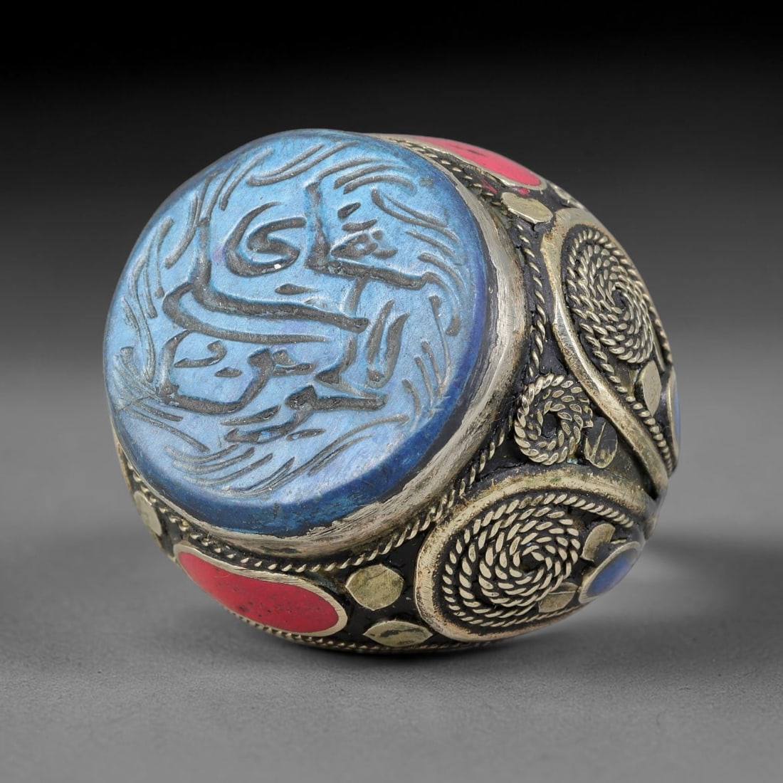 Vintage Islamic Handcrafted Silver Plated Calligraphic Talisman Statement Ring, 34AJ: This vintage hand-wrought Islamic statement ring features a central engraved panel bearing traditional calligraphic detailing, set within an ornate silver-plated metal band. The mounting is enriched w