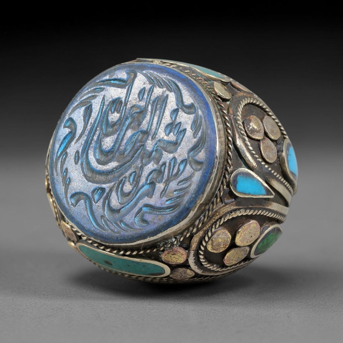 Vintage Islamic Handcrafted Silver Plated Calligraphic Talisman Statement Ring, 39AJ: This vintage hand-wrought Islamic statement ring features a central engraved panel bearing traditional calligraphic detailing, set within an ornate silver-plated metal band. The mounting is enriched w