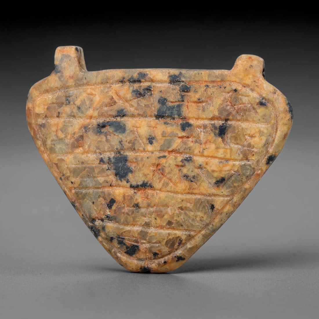 Ancient Uruk Period Triangular Inscribed Apotropaic Amulet (c.3500-3100 BCE), 3AK: Triangular-shaped apotropaic amulet from the Uruk cultural sphere, fitted with two suspension lugs at the upper edge to enable personal wear. The front surface is divided into horizontal registers fil