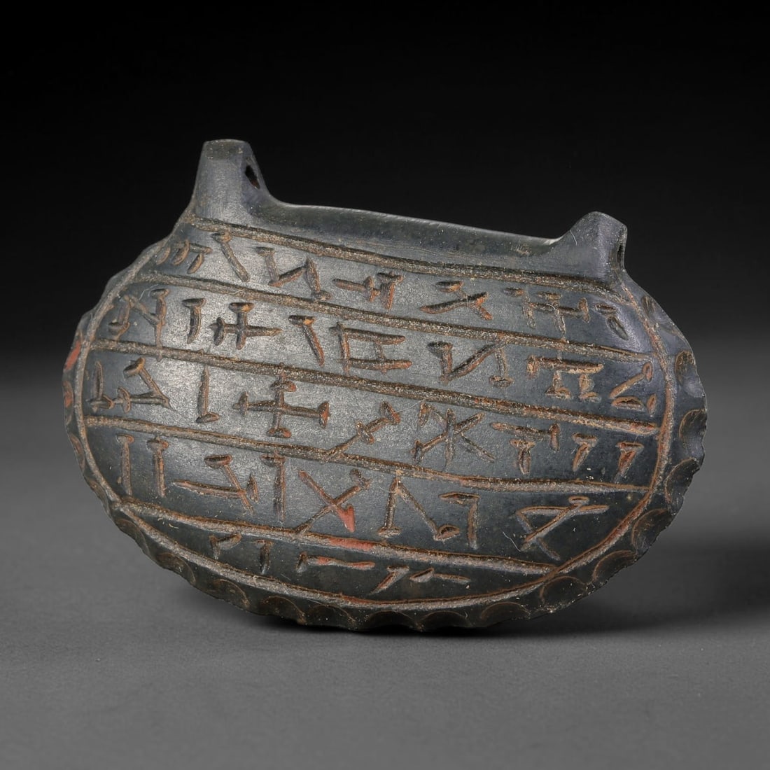 Ancient Uruk Period Oval Inscribed Apotropaic Amulet (c.3500-3100 BCE), 100AJ: Oval-bodied apotropaic amulet from the Uruk cultural sphere, with dual integrated suspension lugs at the upper edge for personal suspension. Its face is laid out in horizontal registers containing inc
