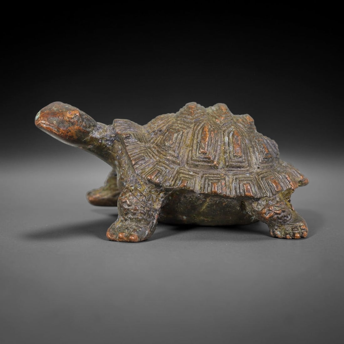 A Chinese Bronze Tortoise Figurine Effigy, 21AD: Cast in bronze, this naturalistic tortoise sculpture is modelled in a walking pose with outstretched neck. Fine detailed relief rendering defines the segmented geometric shell patterns, textured scaly