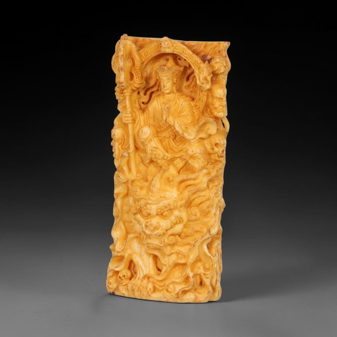 A Chinese Ksitigarbha Deity Carved Tagua Nut Pendant Amulet, 3AD: Carved from tagua nut, also known as ivory nut or vegetable ivory, the pendant takes the form of a rectangular plaque decorated in relief. The obverse depicts Ksitigarbha, shown wearing a jeweled crow