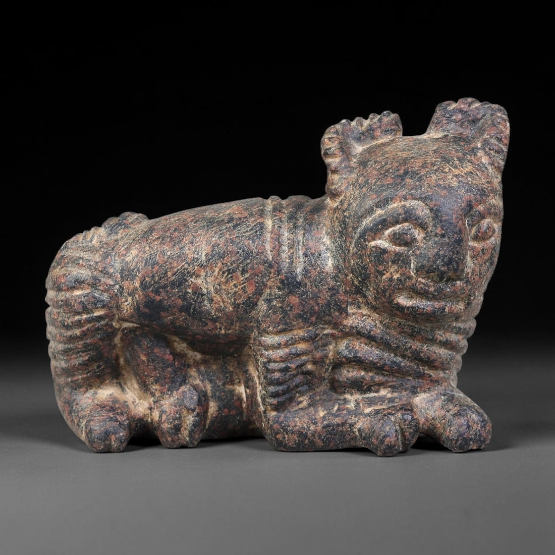 Ancient Elamite Civilization Recumbent Composite Stone Figurine (3200-539 BCE), 26AK: This carved mottled stone composite creature figurine originates from Elamite Civilization, depicting a recumbent hybrid form with stylized anthropomorphic facial features, decorated mane details and 