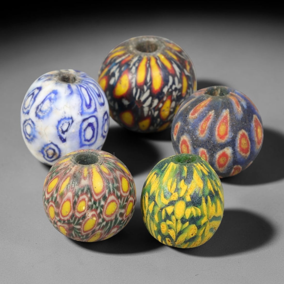 Antique Borneo Millefiori Glass Trade Beads Parcel Lot, 19BC: Collection of historic Borneo millefiori glass trade beads, displaying complex composite cane-work patterns across each spherical specimen. These antique trade examples exhibit age-related surface wea