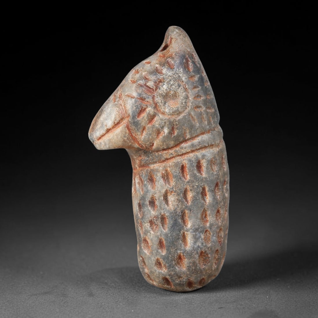 Ancient Sasanian Persian Hard-Stone Ibex-Head Talisman Amulet (224-651 CE), 62AJ: Carved stone amulet modelled as an ibex head and neck, characteristic of Sasanian Persian protective talisman craft. The surface is densely decorated with punched and incised dot-and-circle motifs, wi