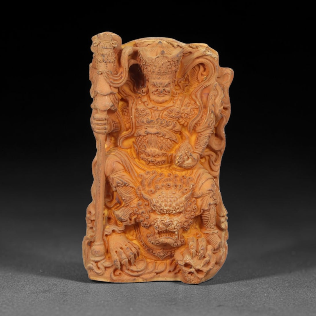 A Chinese Guardian Deity Carved Tagua Nut Pendant Amulet, 6AD: Carved from tagua nut, also known as ivory nut or vegetable ivory, the pendant takes the form of a rectangular plaque decorated in relief. The obverse depicts a Buddhist guardian deity, shown wearing 