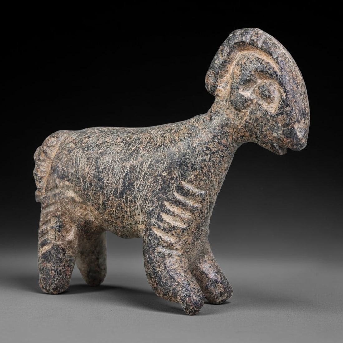 Ancient Elamite Civilization Stone Ram Zoomorphic Figurine Amulet (3200-539 BCE), 75AJ: This ancient stone ram zoomorphic figurine amulet originates from Elamite Civilization, an auspicious apotropaic object reflecting Southwest Iranian ritual iconography. The standing ram figurine featu