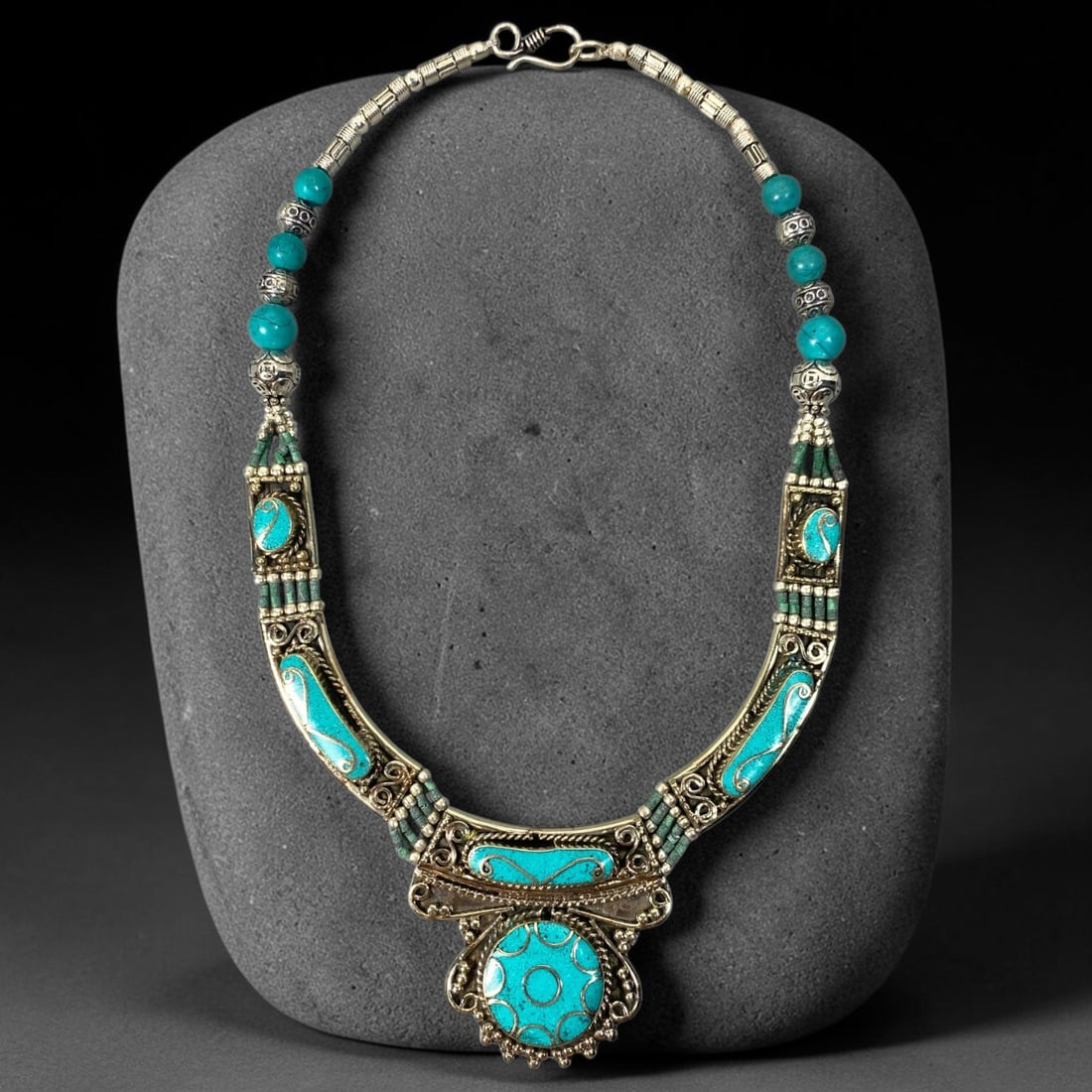 A Central Asian Multi-Metal Turquoise Inlaid Necklace, 4AL: Multi-metal necklace assembled with spherical turquoise beads and decorated textured metal beads along the upper chain. Curved frontal panels hold multiple bezel-set turquoise insets, complemented by 