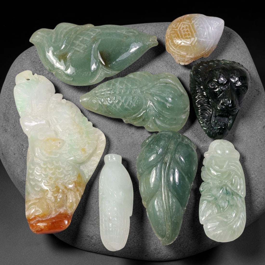 219ct Natural Burmese Type A Jadeite Jade Carving Pendant Parcel Lot, 87EX: This parcel lot consists of hand-carved Type A jadeite pendants displaying varied natural colour tones including deep forest green, soft pale green, and warm yellow-gold hues. Each piece finished with