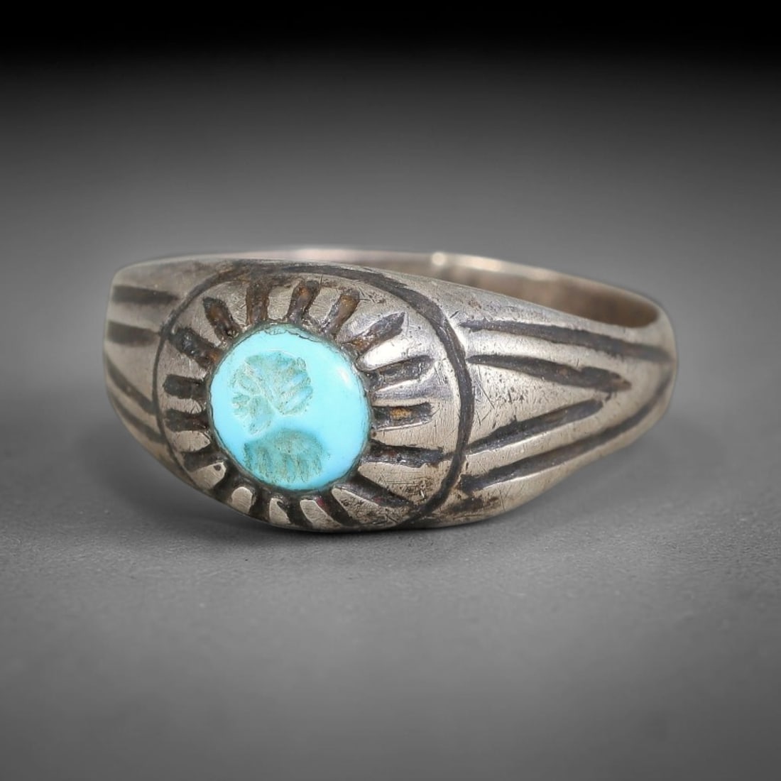 Antique Ottoman Turquoise Round Intaglio Radiating Bezel Silver Ring, 41AL: Silver ring of the Ottoman period set with a round turquoise intaglio with carved motif, housed within a radiating sunburst incised bezel. Parallel linear engraved decoration extends across the domed 