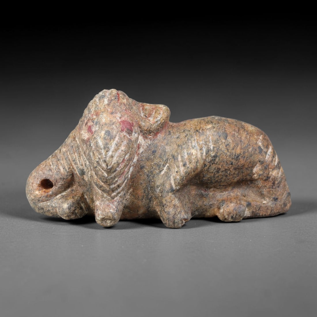Ancient Gandharan Schist Recumbent Elephant Effigy (1st-4th Century CE), 67AJ: Carved schist stone effigy depicting a recumbent elephant, rendered in classic Gandharan sculptural tradition. Fine incised linear detailing defines the creature's hide folds, facial features and trun