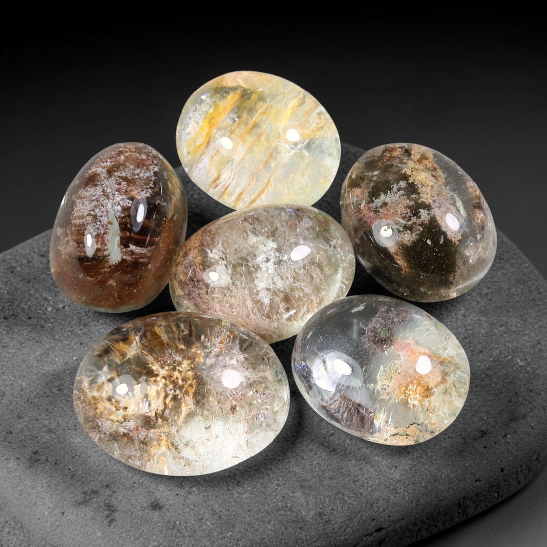139.81ct Natural Brazilian Phantom Quartz Cabochon Parcel Lot, 69EW: This polished cabochon parcel of natural phantom quartz features transparent clear quartz host stone enclosing intricate internal phantom mineral deposits. Each oval cabochon displays unique scenic in