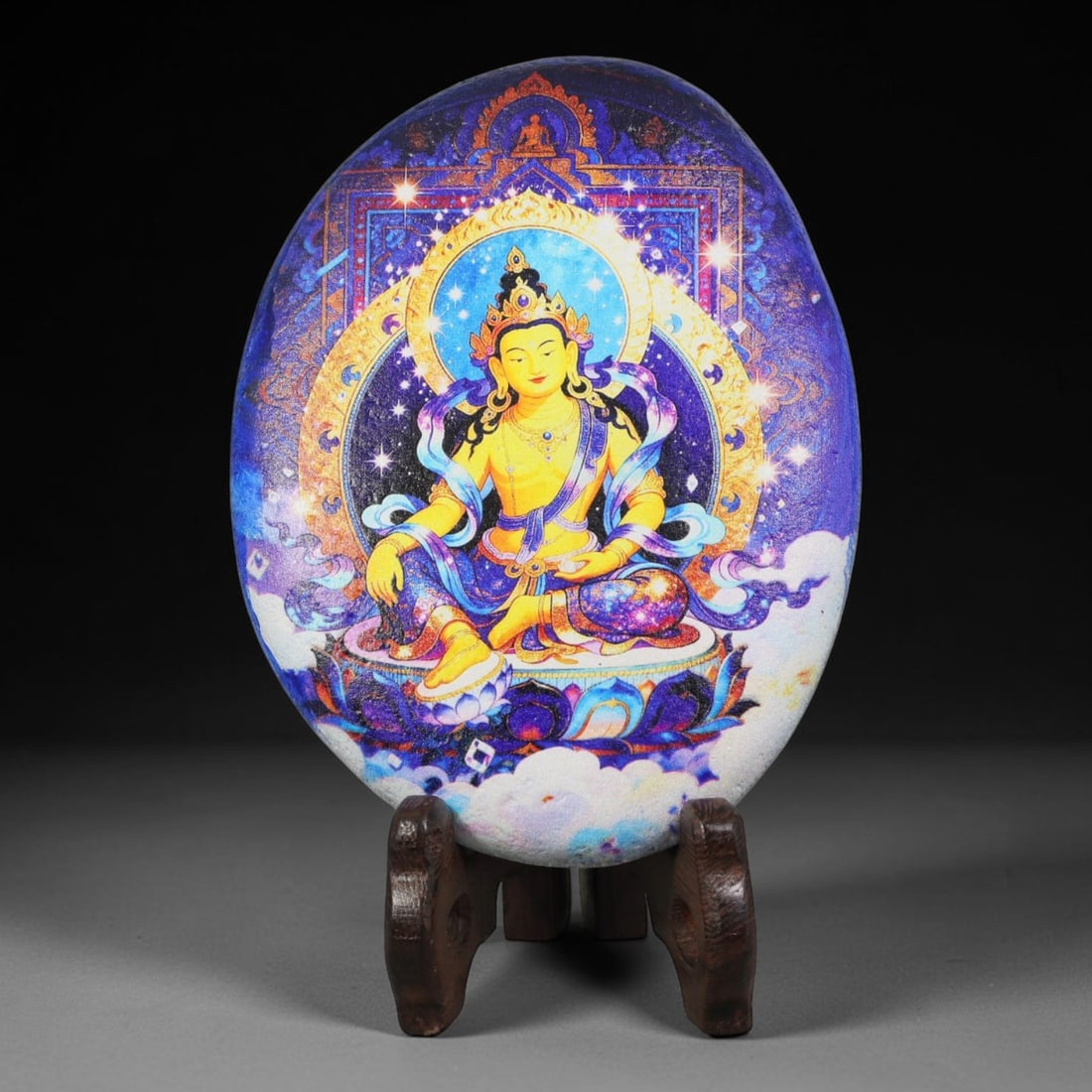 A Tibetan Thangka Style Painted River Stone with a Bodhisattva Figure, 63BC: Painted on a naturally rounded river stone, the work depicts a seated bodhisattva figure in a thangka-style composition. The figure is shown in a seated posture with ornate adornments, set against a b