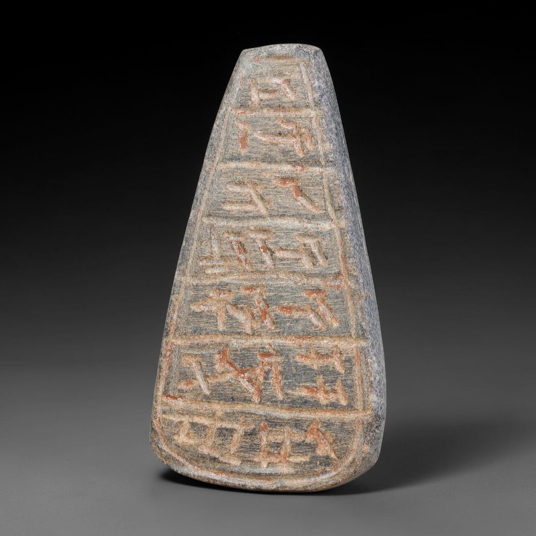 Ancient Uruk Period Tapering Inscribed Apotropaic Amulet (c.3500-3100 BCE), 7AK: Tapering wedge-form apotropaic amulet of the Uruk cultural tradition, its surface partitioned into stacked horizontal registers filled with incised archaic symbolic script. Reddish-hued residue remain