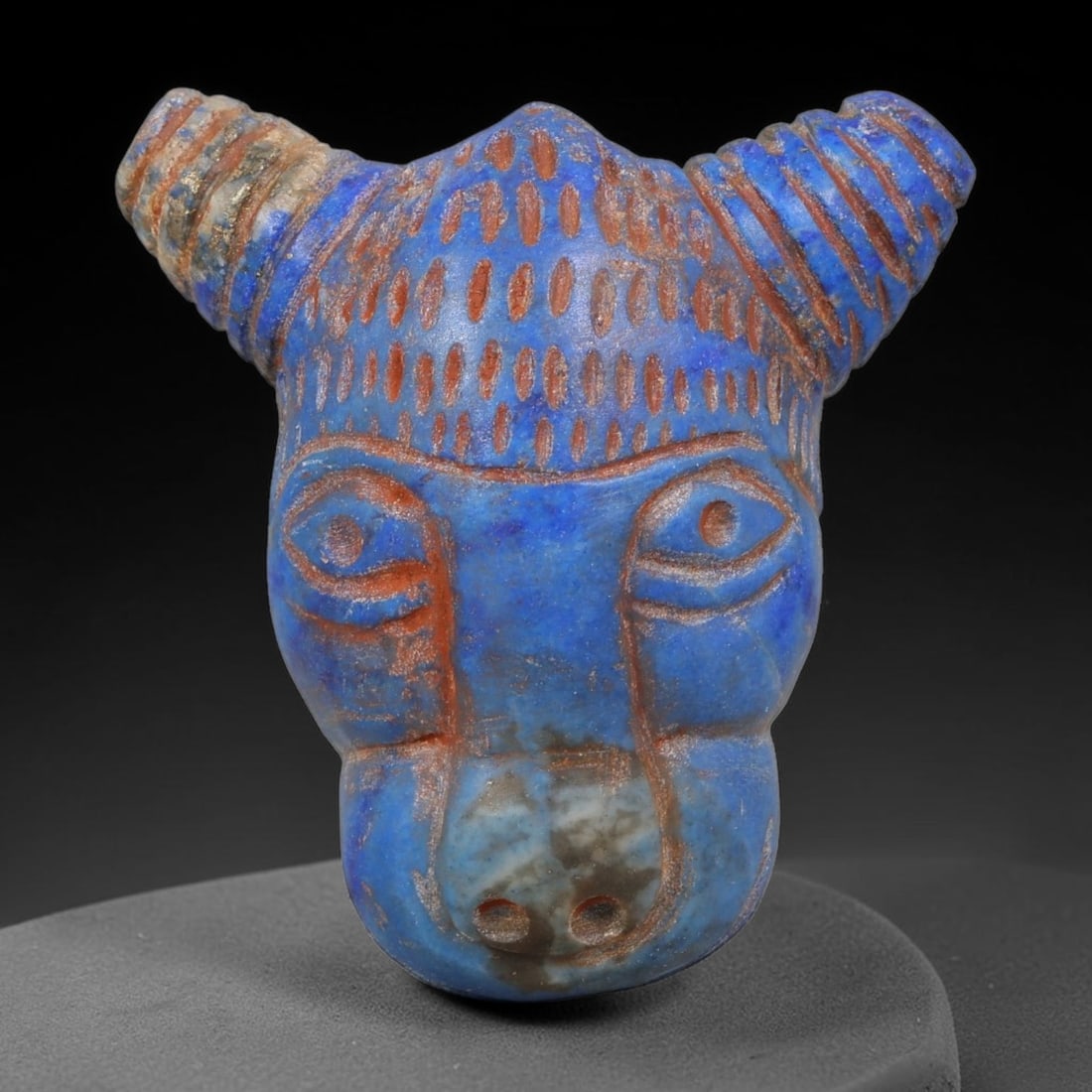 Ancient Sasanian Persian Lapis Lazuli Bull-Head Amulet (224-651 CE), 35AK: This finely carved lapis lazuli bull-head amulet originates from the Sasanian Persian Empire, created as a protective Zoroastrian talisman characteristic of late antique Persian lapidary craft. Deep r