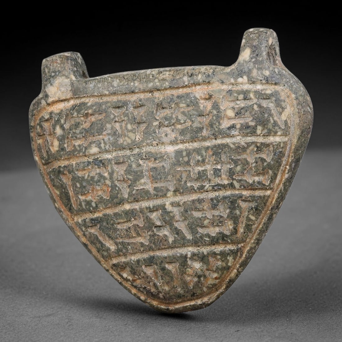 Ancient Uruk Period Heart-Shaped Inscribed Apotropaic Amulet (c.3500-3100 BCE), 4AK: Heart-shaped apotropaic amulet from the Uruk cultural sphere, equipped with dual suspension lugs at the upper edge for personal wear. Its face is divided into horizontal registers filled with incised 