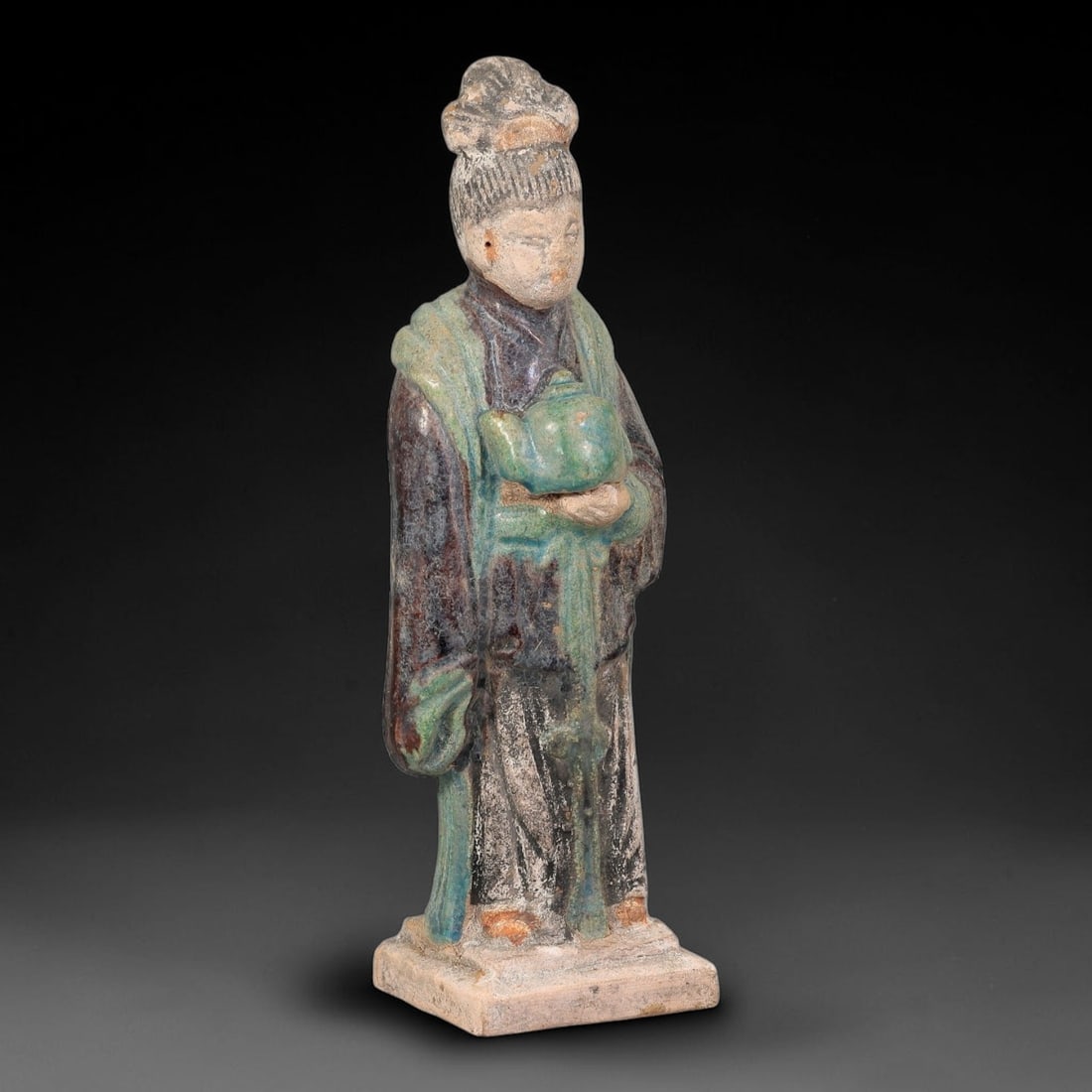 A Chinese Ming Dynasty Glazed Terracotta Female Attendant Figurine, 85AL: Modelled in hollow terracotta, the standing female attendant retains polychrome glaze and pigment. The figure has an elevated coiffure, defined facial features, and pigmented facial details. She wears