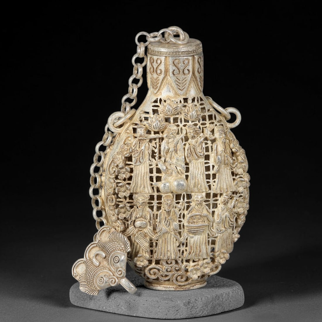A Chinese German Silver Openwork Ladies Figural Snuff Bottle, 66AV: Pear-shaped German silver snuff bottle executed in elaborate openwork on both sides, decorated with ladies in traditional robes, flowers, scrollwork and lattice-patterned grounds. The stopper is conne