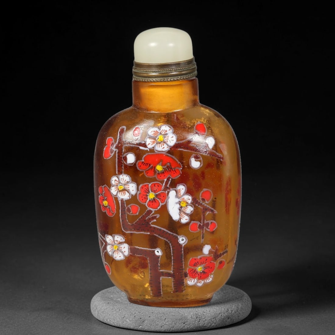 A Chinese Amber Glass Enamel Plum Blossom Snuff Bottle, 43AV: Rectangular flattened snuff bottle crafted from translucent amber glass, decorated with hand-painted polychrome enamel plum blossoms and gnarled branches. The neck is fitted with a brass mount and smo