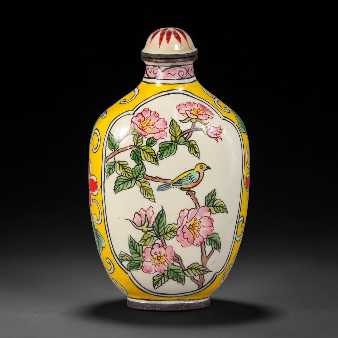A Chinese Bronze Enamel Bird and Flower Snuff Bottle, 97AV: Oblong bronze snuff bottle decorated in painted enamel, featuring a central reserved panel depicting a songbird perched amid blossoming flowers, framed by a vibrant yellow ground with scrolling floral