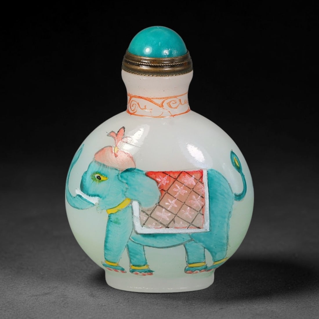 A Chinese White Glass Enamel Elephant Snuff Bottle, 41AV: Globular opaque white glass snuff bottle hand painted in colourful enamel depicting a decorated elephant with ornamental headdress, collar and patterned saddle cloth. The neck features delicate red sc