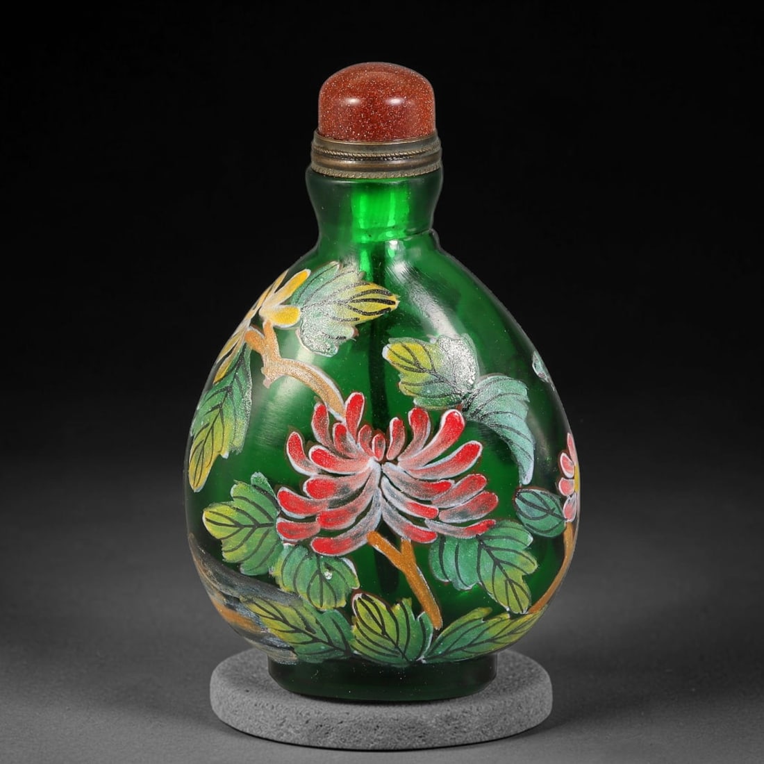 A Chinese Green Peking Glass Enameled Floral Snuff Bottle, 53AV: Ovoid snuff bottle crafted from translucent green Peking glass, decorated with hand-painted enamel chrysanthemum blossoms and foliage in vibrant hues. The base bears a Qianlong reign mark. It is fitte
