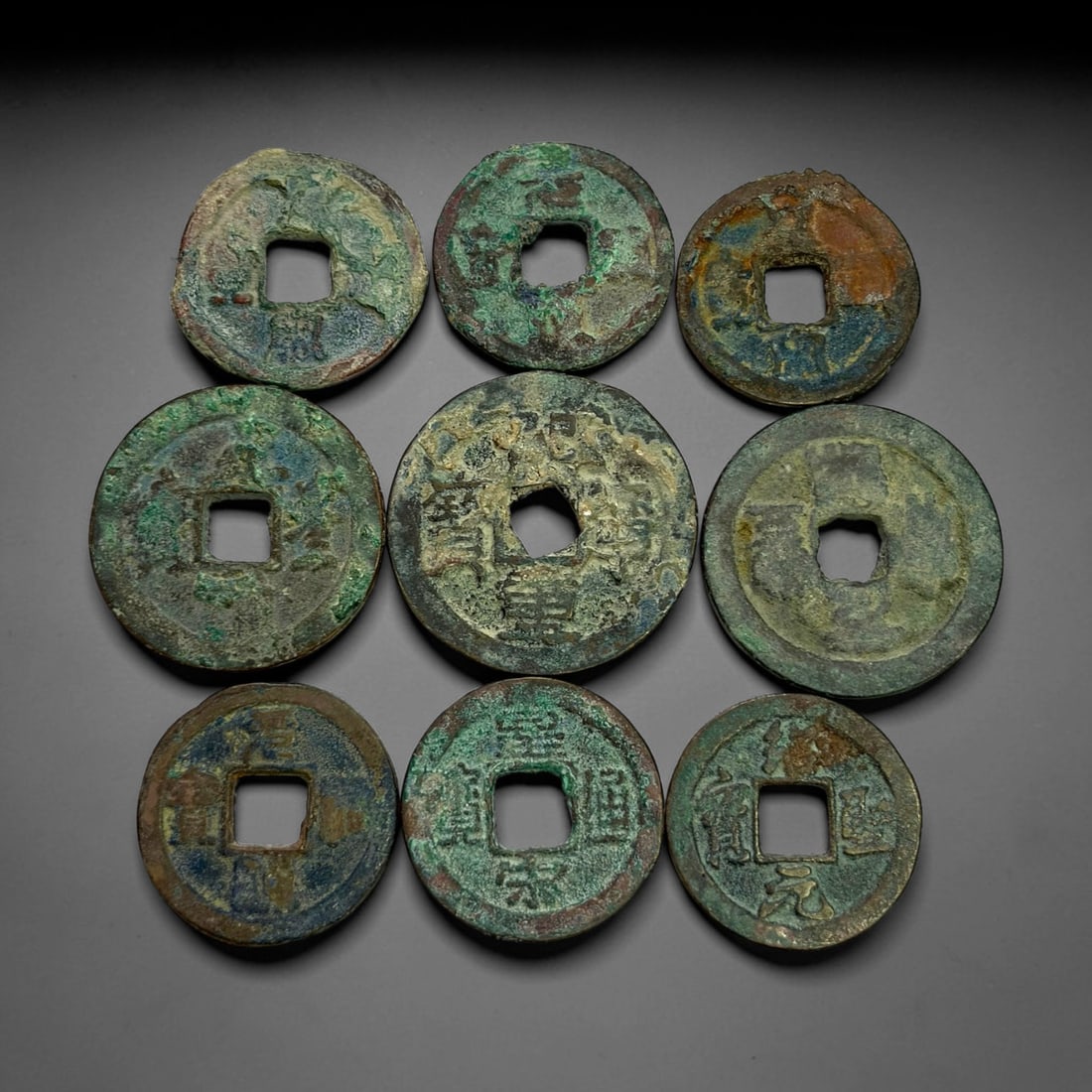 Lot of 9 Ancient Chinese Song Dynasty Bronze Cash Coins, 9BD: A collection of nine bronze square-hole cash coins from the Song dynasty. Each coin bears inscribed coinage characters on the obverse, with varied patina, verdigris and earthen encrustation accumulate