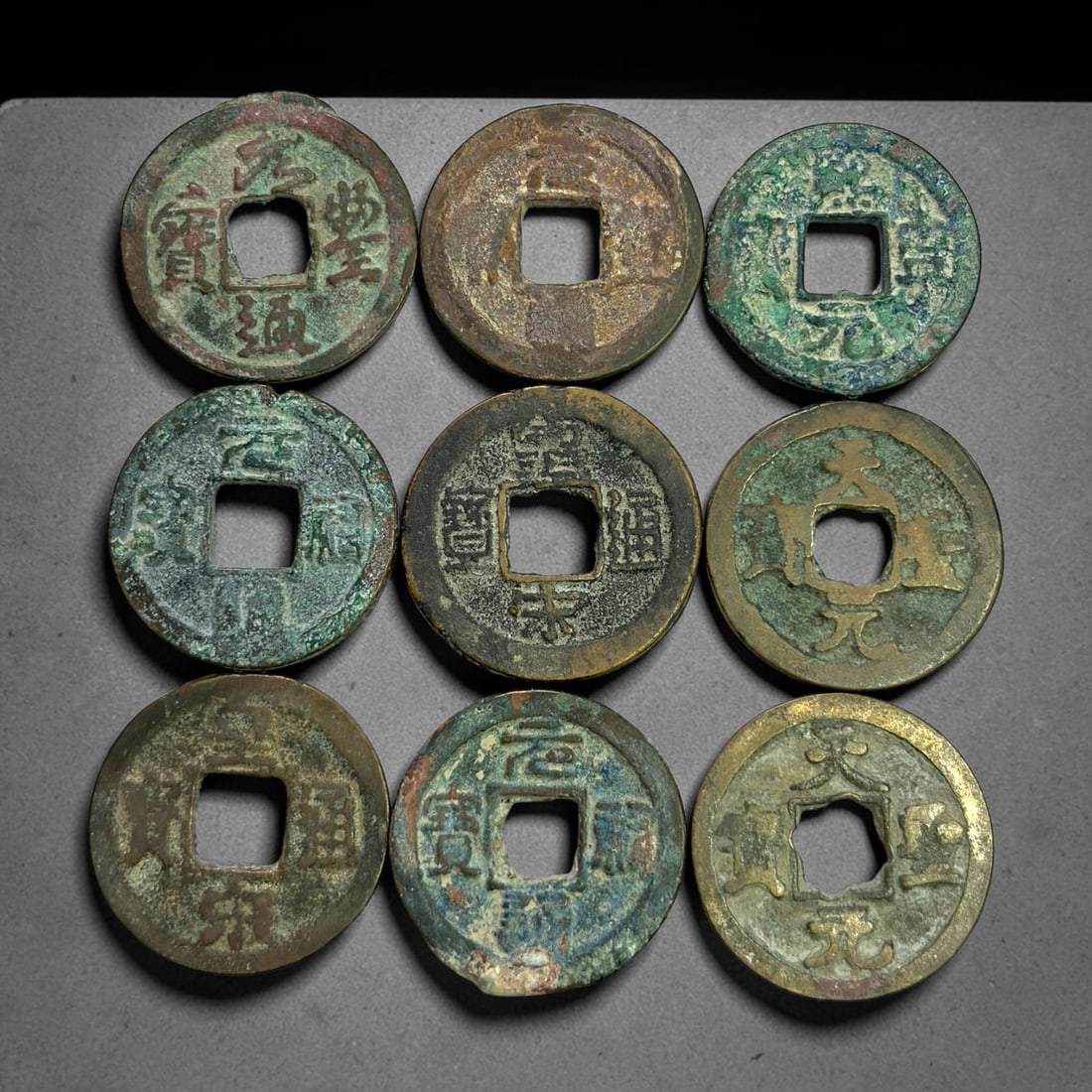Lot of 9 Ancient Chinese Song Dynasty Bronze Cash Coins, 4BD: A collection of nine bronze square-hole cash coins from the Song dynasty. Each coin bears inscribed coinage characters on the obverse, with varied patina, verdigris and earthen encrustation accumulate