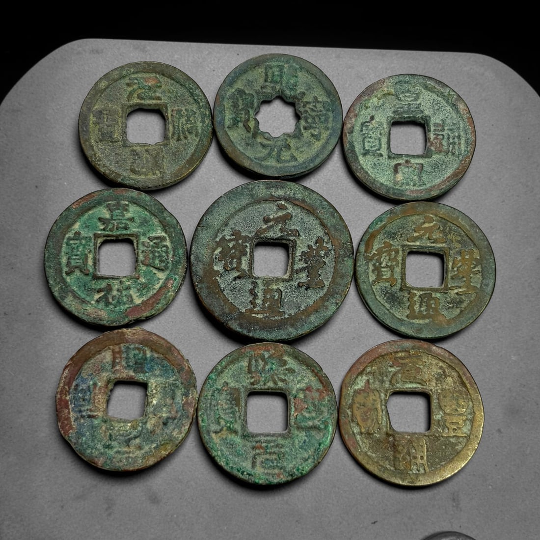 Lot of 9 Ancient Chinese Song Dynasty Bronze Cash Coins, 5BD: A collection of nine bronze square-hole cash coins from the Song dynasty. Each coin bears inscribed coinage characters on the obverse, with varied patina, verdigris and earthen encrustation accumulate
