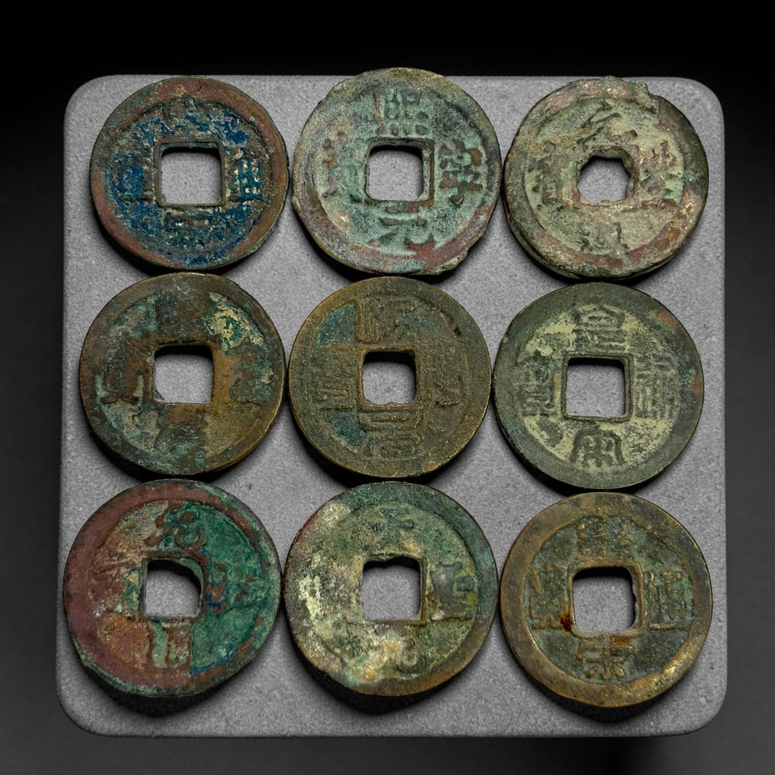 Lot of 9 Ancient Chinese Song Dynasty Bronze Cash Coins, 13BD: A collection of nine bronze square-hole cash coins from the Song dynasty. Each coin bears inscribed coinage characters on the obverse, with varied patina, verdigris and earthen encrustation accumulate