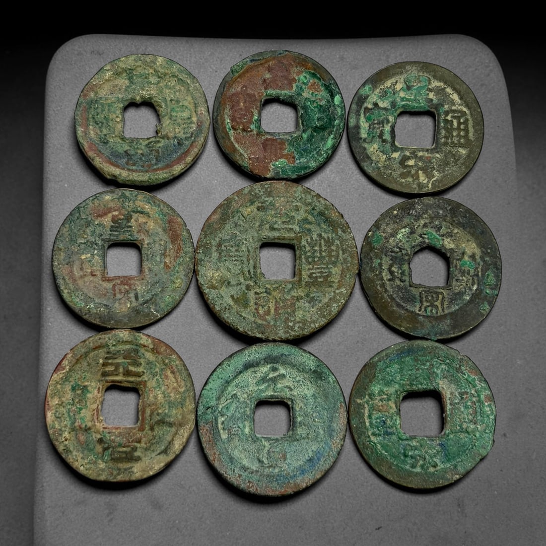 Lot of 9 Ancient Chinese Song Dynasty Bronze Cash Coins, 11BD: A collection of nine bronze square-hole cash coins from the Song dynasty. Each coin bears inscribed coinage characters on the obverse, with varied patina, verdigris and earthen encrustation accumulate
