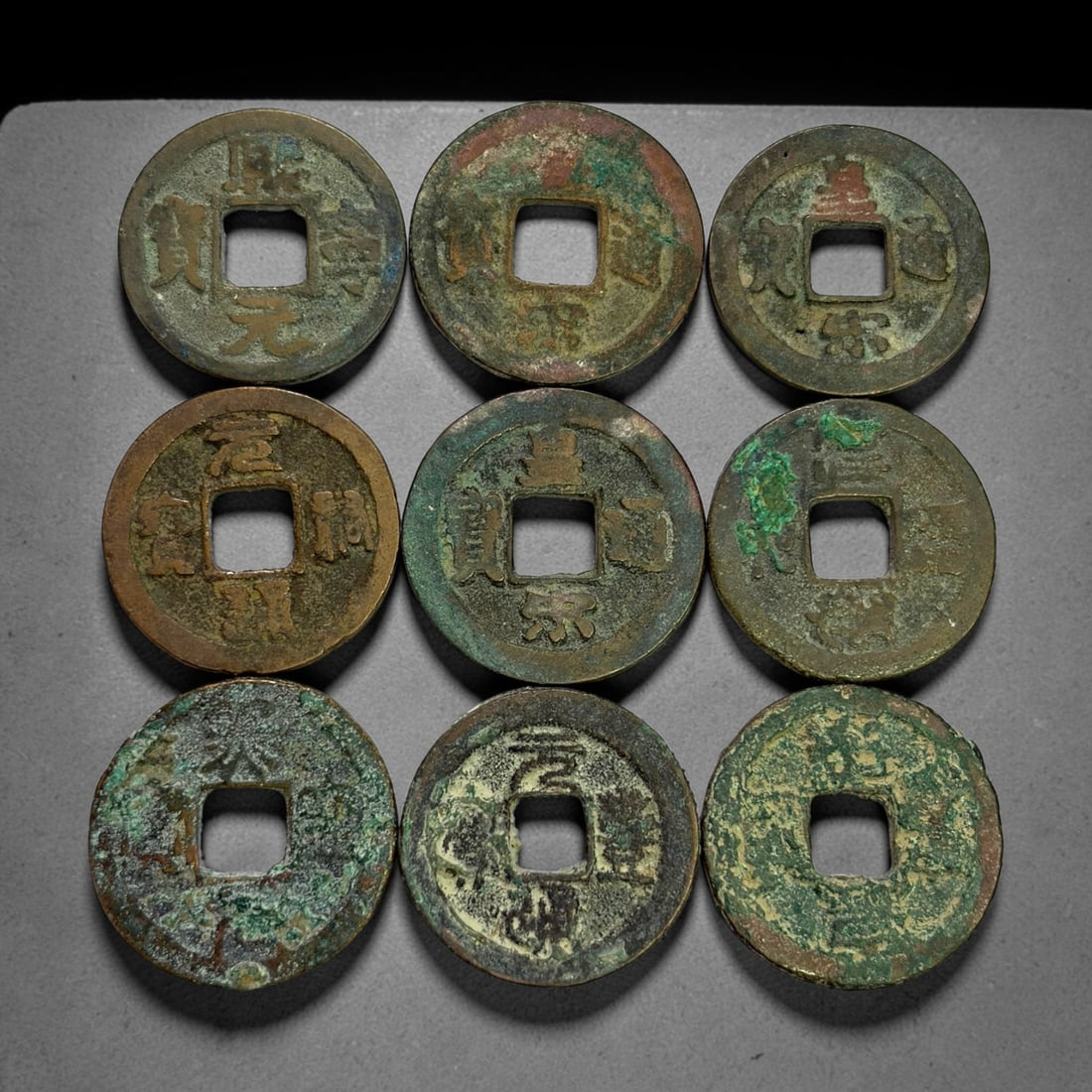 Lot of 9 Ancient Chinese Song Dynasty Bronze Cash Coins, 6BD: A collection of nine bronze square-hole cash coins from the Song dynasty. Each coin bears inscribed coinage characters on the obverse, with varied patina, verdigris and earthen encrustation accumulate