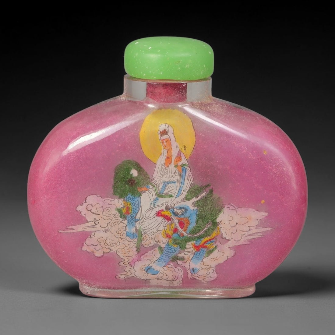 A Chinese Inside Painted Glass Snuff Bottle with Guanyin Motif, 79AV: Flattened globular glass snuff bottle with translucent pink ground, finely decorated with interior painting depicting Guanyin seated atop a mythical beast amid billowing clouds, with a radiant golden 