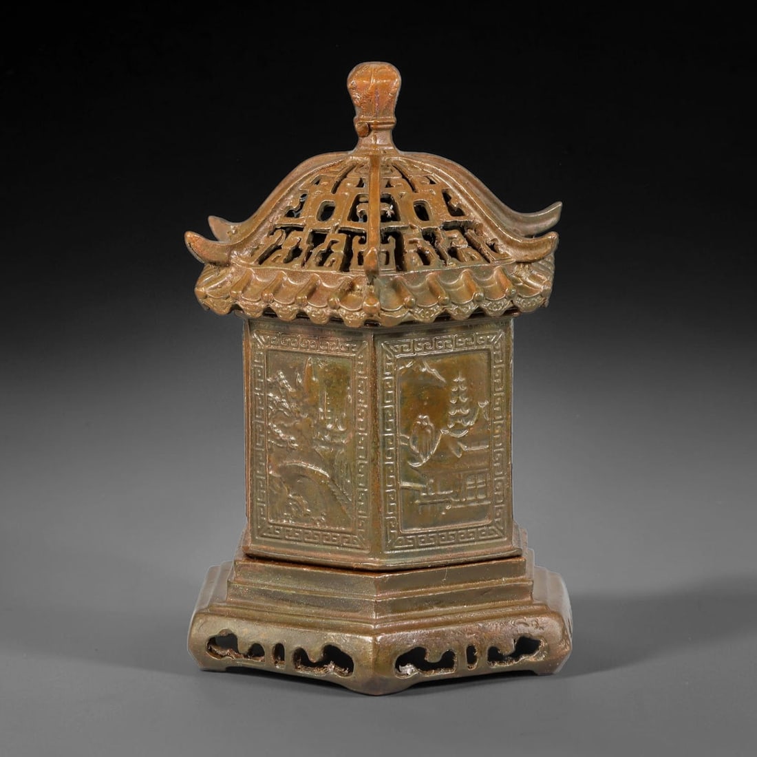 A Chinese Hexagonal Pagoda Form Bronze Censer, 16AX: Cast bronze hexagonal censer modelled as a traditional Chinese pagoda. The openwork roof lid features upturned eaves and geometric pierced patterns, crowned by a bud finial. Each vertical panel of the