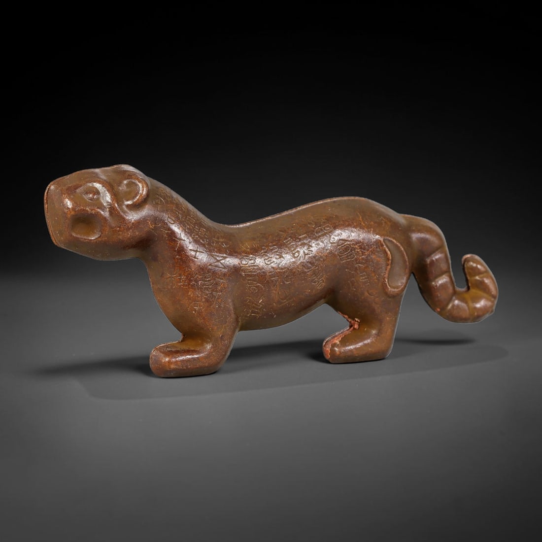 A Chinese Bronze Tiger Tally, 51AX: Cast bronze tiger tally formed as two interlocking halves, modelled in the shape of a prowling tiger with incised inscriptions across the body, curled tail and defined facial features. The bronze surf