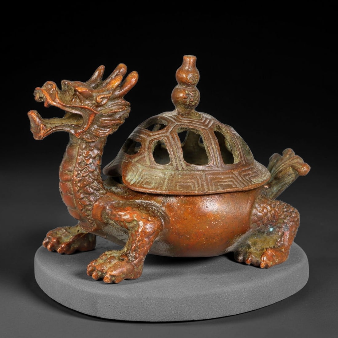 A Chinese Bronze Dragon Turtle Pierced Covered Censer, 57AX: Cast bronze censer modelled in the form of a dragon turtle, featuring a fully detailed dragon head, scaled limbs and textured shell. The removable lid is pierced with geometric openings for incense em