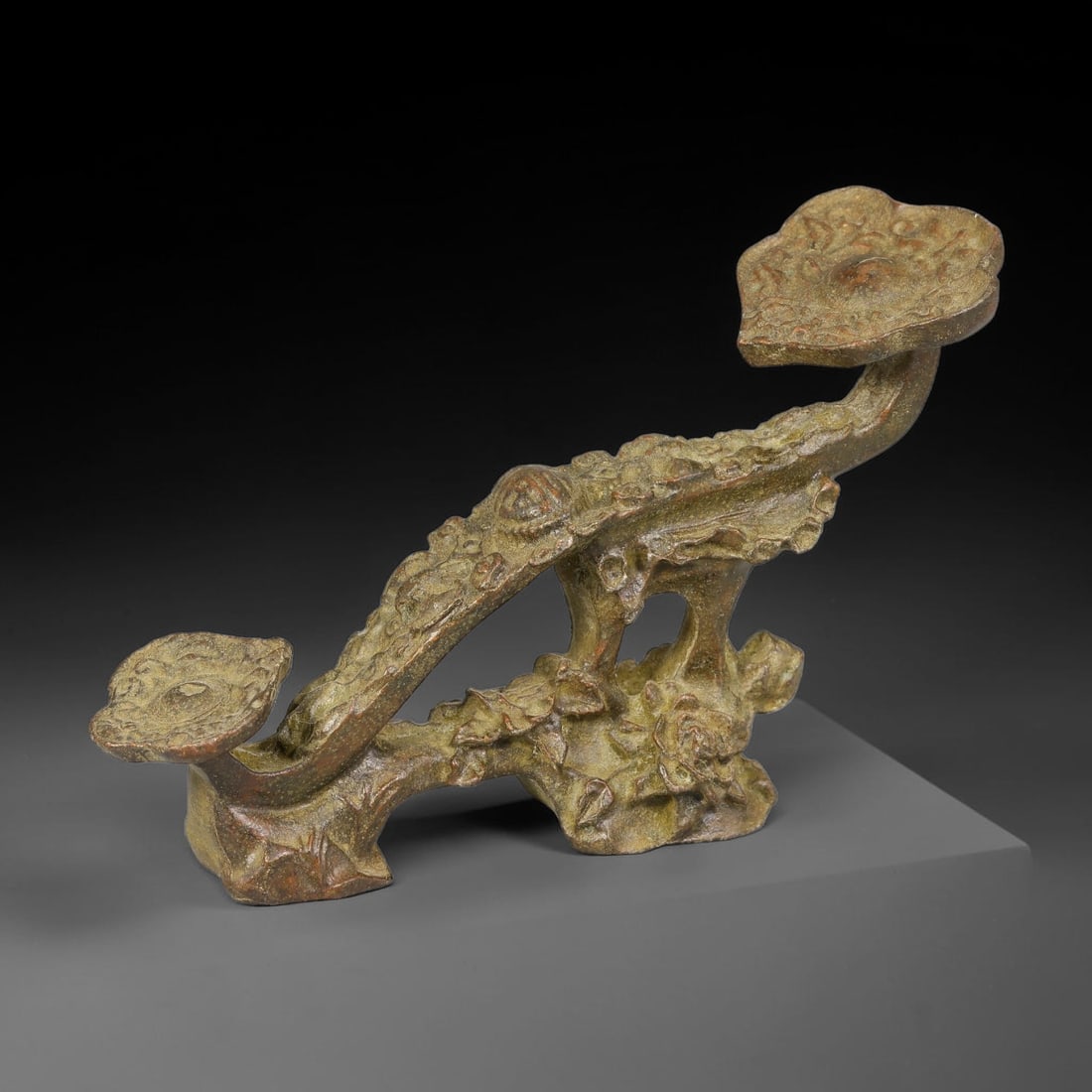 A Chinese Bronze Double Lingzhi Ruyi Ornament, 46BD: Cast bronze ruyi ornament formed as a gnarled branching stem supporting two lingzhi fungus heads, with detailed textured surface mimicking natural bark and fungal growth patterns. The bronze carries a