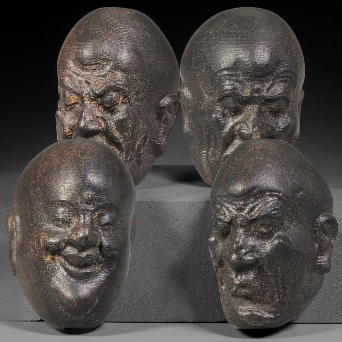 Lot of Four Chinese Agar Wood Carved Luohan Head Beads, 12BF: Group of four hand-carved agar wood beads, each modelled as a distinct Luohan head with varied facial expressions and detailed facial textures. Each bead is fully drilled for threading. The wood exhib