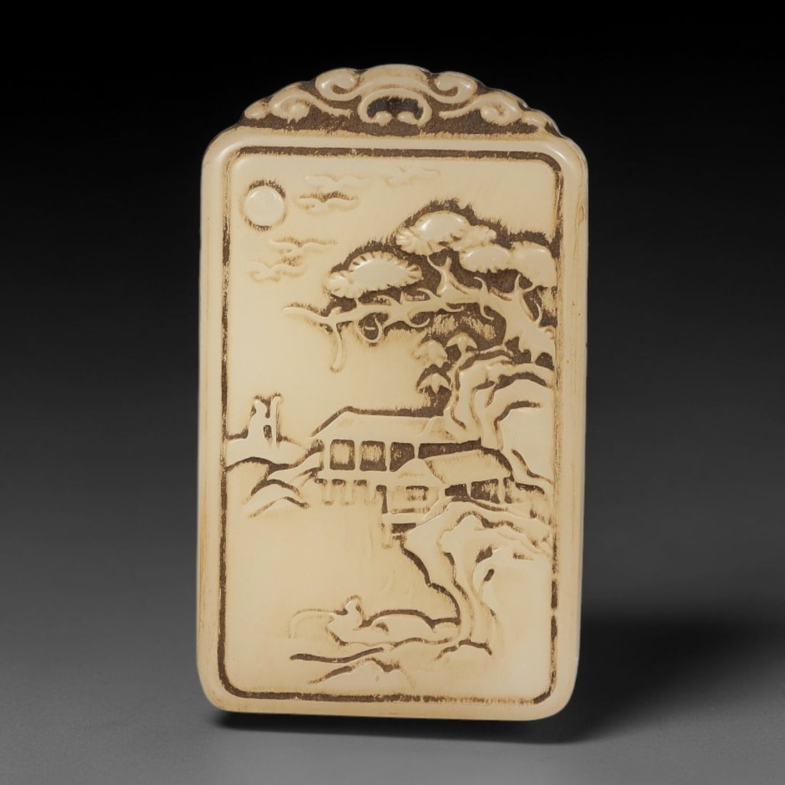 A Chinese Carved Pale Jade Landscape Plaque Pendant, 39BD: Rectangular pale jade plaque with ornate scrollwork carving on the upper suspension header. The main face is decorated in relief with a traditional Chinese landscape scene featuring pine trees, a wate