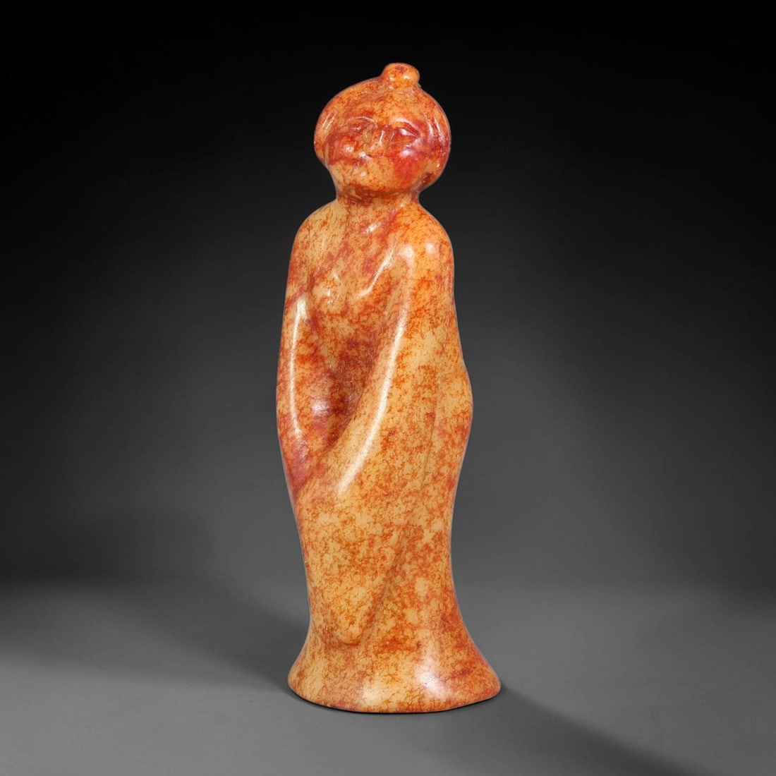 A Chinese Carved Jade Standing Court Lady Figure, 15BD: Carved jade figure depicting a standing lady in flowing wrapped robes, with neatly styled topknot hairstyle and softly modelled facial features. The stone exhibits a pale cream base overlaid with mott
