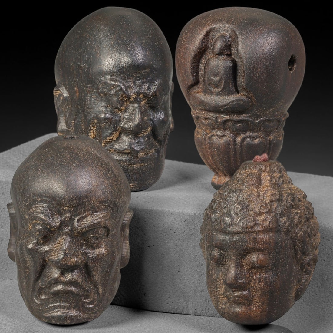 Lot of Four Chinese Agar Wood Carved Luohan Head Beads, 13BF: Group of four hand-carved agar wood beads, each modelled as a distinct Luohan head with varied facial expressions and detailed facial textures. Each bead is fully drilled for threading. The wood exhib