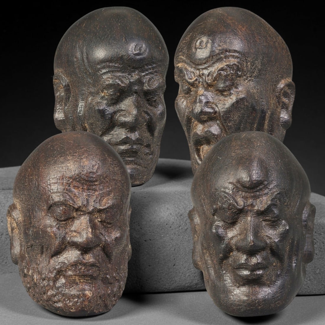 Lot of Four Chinese Agar Wood Carved Luohan Head Beads, 14BF: Group of four hand-carved agar wood beads, each modelled as a distinct Luohan head with varied facial expressions and detailed facial textures. Each bead is fully drilled for threading. The wood exhib