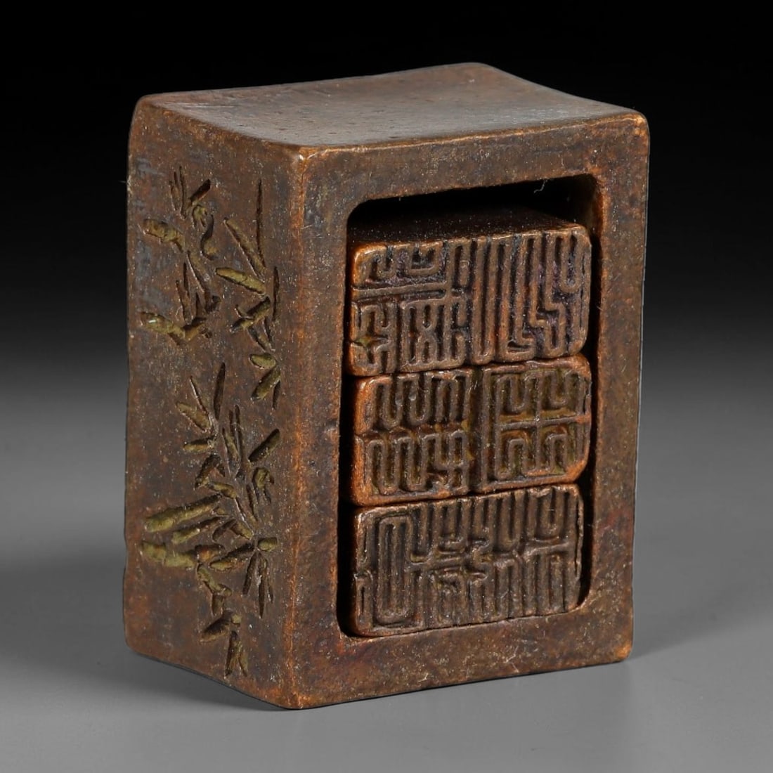A Chinese Bronze Multi-Component Nesting Seal with Carved Bamboo Decoration, 49AX: Cast bronze nested seal set consisting of one outer rectangular casing enclosing three smaller removable internal seals. The exterior of the outer block is decorated with finely incised bamboo motifs,