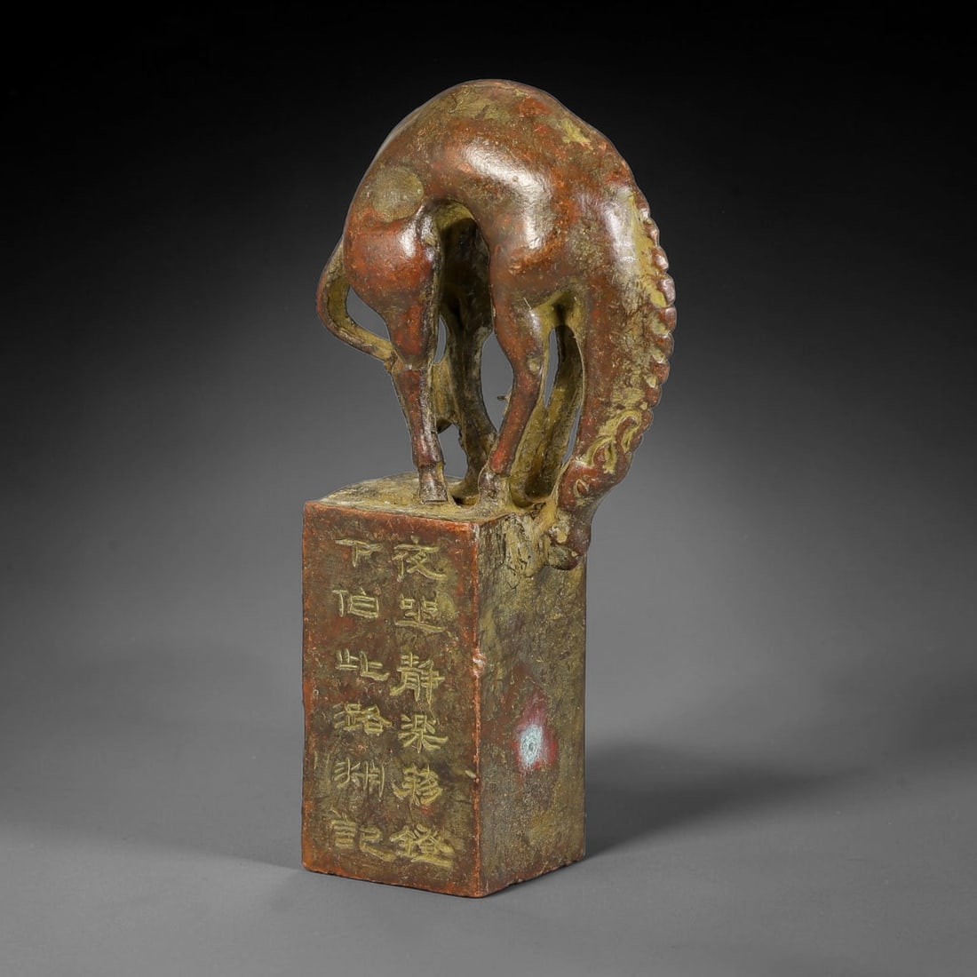 A Chinese Bronze Rectangular Seal with Grazing Horse Knob, 63AX: Cast bronze rectangular seal surmounted by a dynamically modelled grazing horse knob, its neck arched downwards toward the seal block with defined mane and slender limbs. Vertical sides of the seal sh