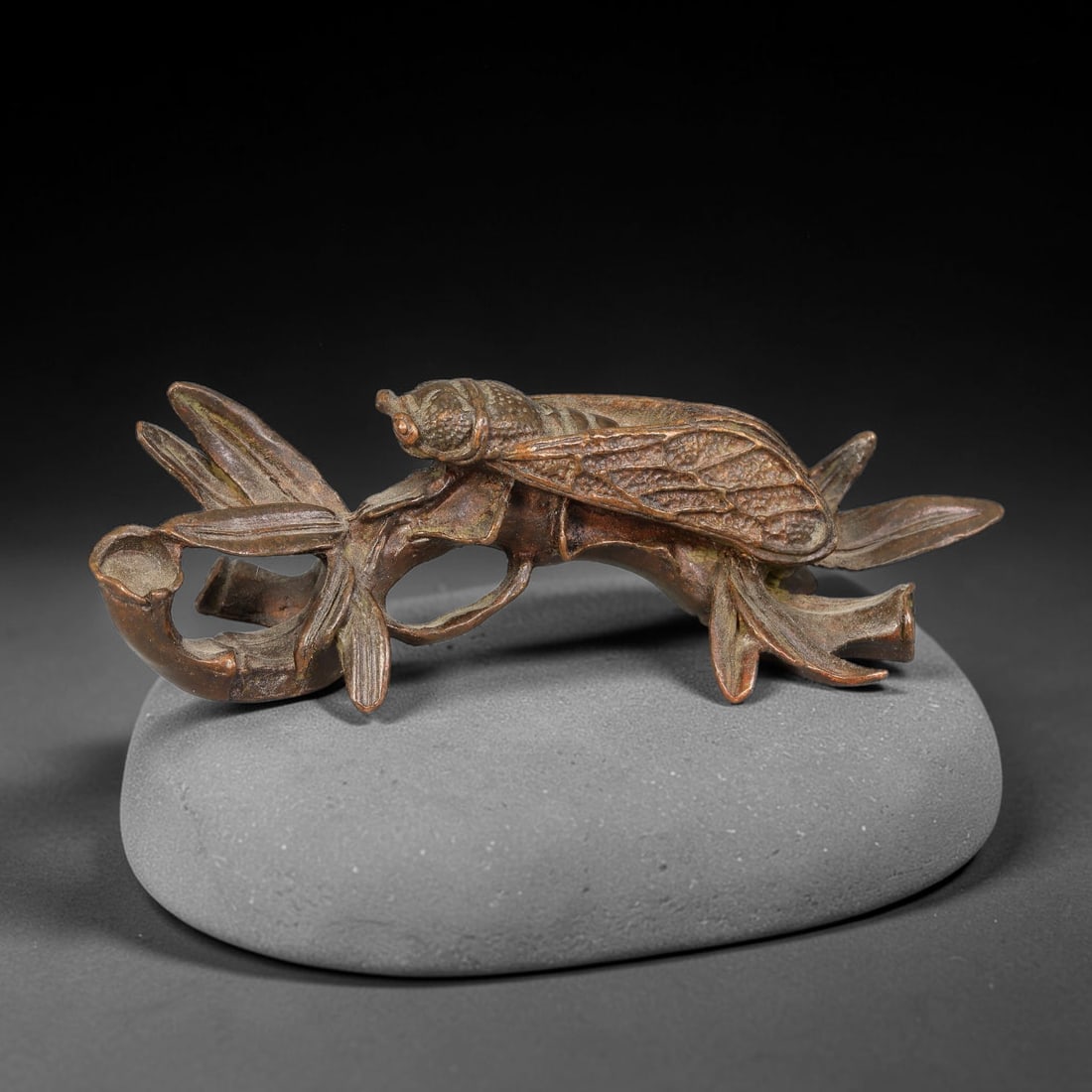 A Chinese Bronze Cicada on Bamboo Figurine, 74AX: Cast bronze group modelled as a detailed cicada perched upon an openwork bamboo sprig, with finely rendered wing veining, segmented bamboo stalks and pointed leaf forms. The bronze displays a warm age