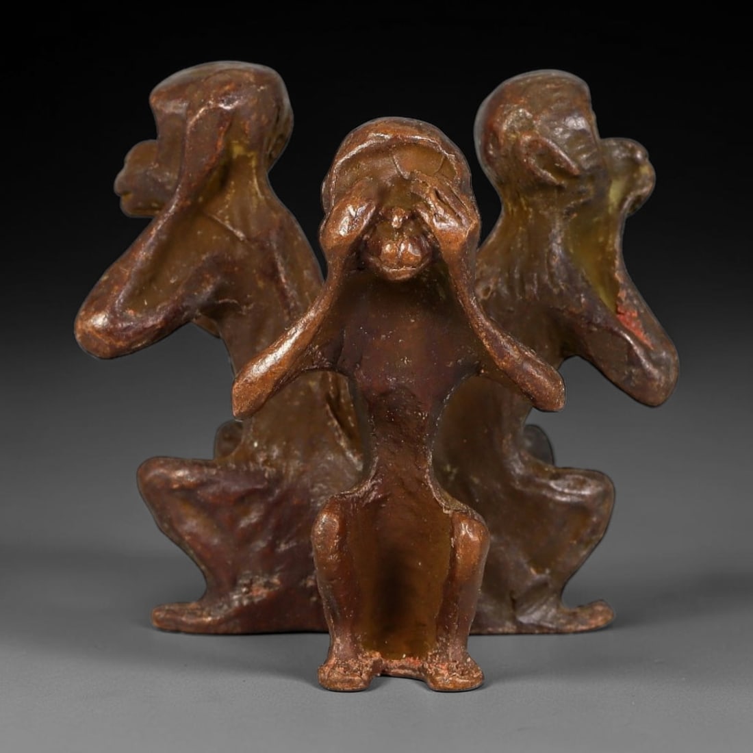 A Chinese Bronze Three Wise Monkeys Figurine Group, 27AX: Cast bronze group depicting the classic three wise monkeys, posed seated with traditional gestures: one covering its eyes, one covering its ears, and one covering its mouth. The figures are closely gr