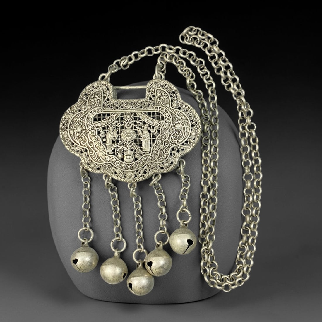 A Chinese Filigree German Silver Lock Pendant Necklace, 94BD: Filigree German silver ruyi-form lock pendant, the obverse featuring openwork figural scene with attendant figures and abundant floral borders. The reverse is finely pierced and decorated with dragon 