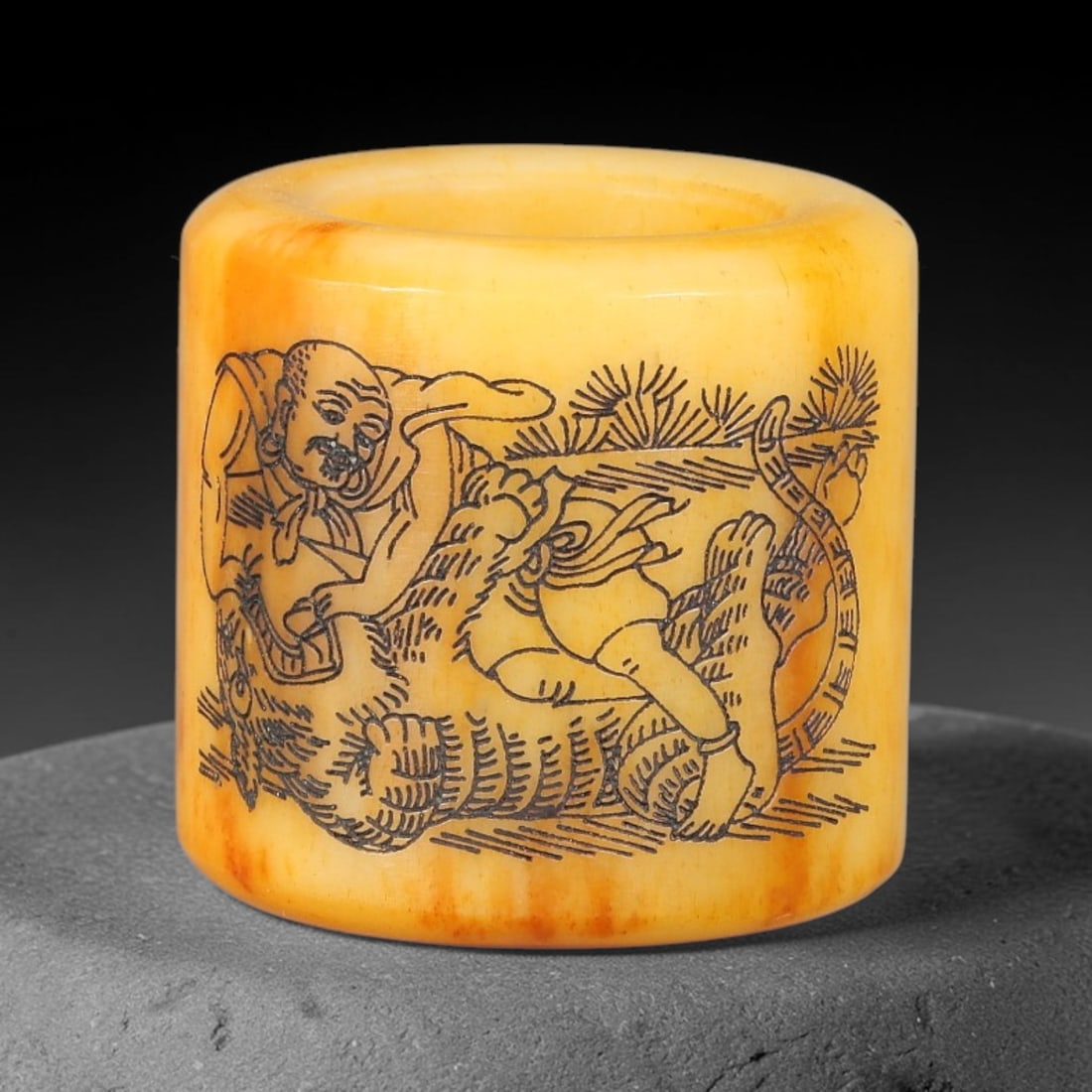 A Chinese Antique Engraved Bone Thumb Ring with Luohan and Poem Inscription, 44BT: This cylindrical bone thumb ring is finely engraved on the exterior with a Luohan seated on a mythical beast, set amid rocky ground, pine branches, and scrolling details. The reverse side bears Chines