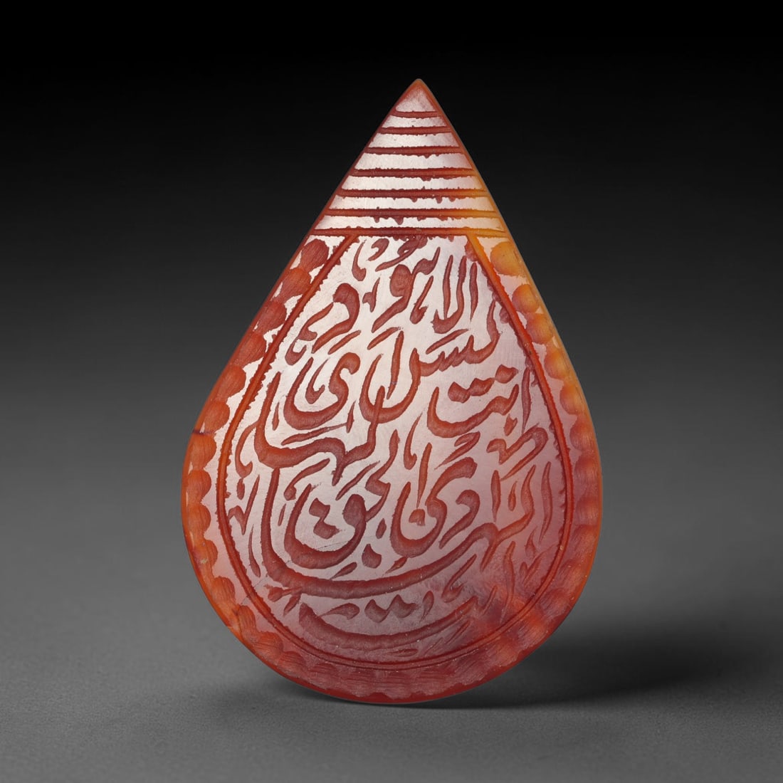 Antique Mughal Style Carnelian Islamic Calligraphic Script Talisman Plaque, 47BL: This talisman plaque is crafted from carnelian, deeply engraved with flowing Islamic calligraphic script across its face, enclosed within a fine engraved border. The meticulous carving captures elegan