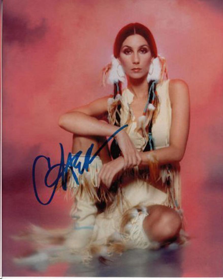 CHER IN TRIBAL DRESS AUTHENTIC SIGNED 8 X 10 PHOTOGRAPH: CHER IN TRIBAL DRESS AUTHENTIC SIGNED 8 X 10 PHOTOGRAPH. THIS ITEM HAS BEEN INSPECTED AND AUTHENTICALLY VERIFIED BY ENCORE AUTOGRAPHS. IT IS NOT A COPY, REPRINT, OR ANY KIND OF FACSIMILE OF THE ARTIST